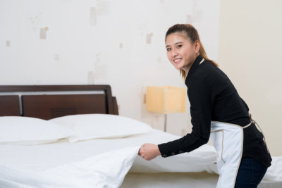 caregiver making bed in a room